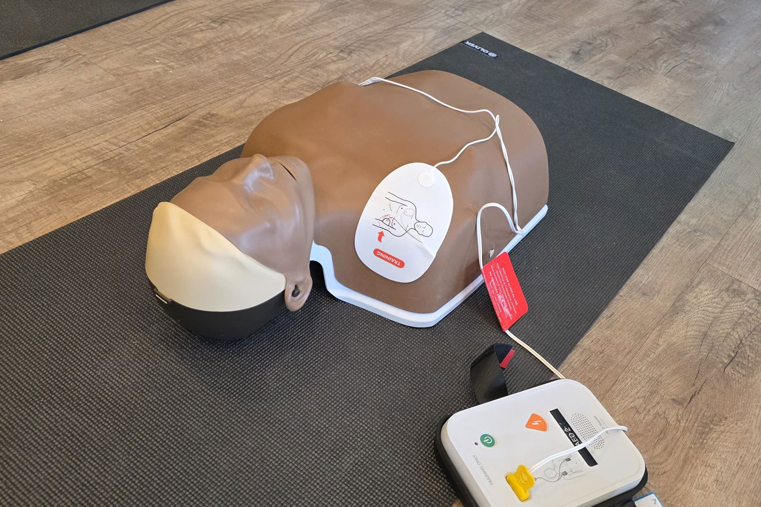 Erste-Hilfe-Trainingspuppe mit angeschlossenem AED-Defibrillator während einer Schulung durch das Schulungszentrum Lüneburger Heide