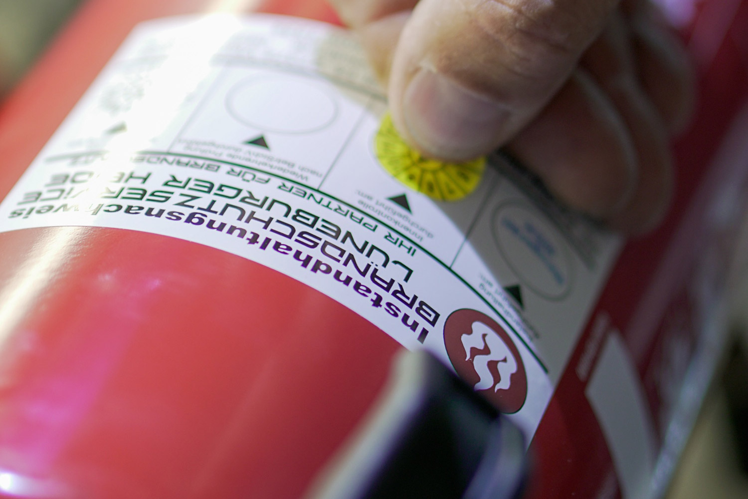 Anbringen einer Prüfplakette auf einem Feuerlöscher durch Brandschutzservice Lüneburger Heide